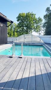 a swimming pool with a wooden deck and a swimming simulator at Brightside House in Kristiansand