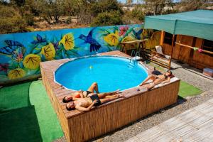 a group of people laying around a swimming pool at Paracas Desert Lodge&Tours in Paracas