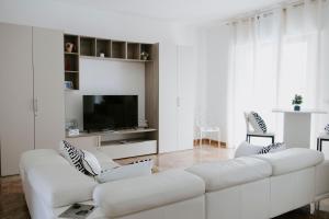 a white living room with a white couch and a tv at BnB Nuova Vita in Paola