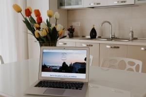 a laptop computer sitting on a table with a vase of flowers at BnB Nuova Vita in Paola +28 photos