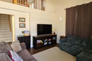 a living room with a couch and a flat screen tv at Leelanau Pines in Suttons Bay