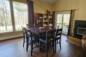 a dining room with a table and chairs and a fireplace at Leelanau Pines in Suttons Bay