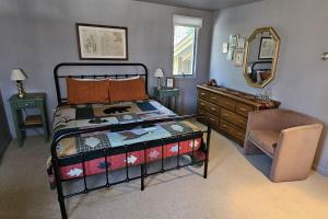 a bedroom with a bed and a dresser and a mirror at Leelanau Pines in Suttons Bay