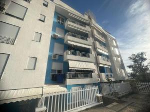 a tall apartment building with balconies and a fence at Beach Studio Apartment in Dhërmi +2 photos
