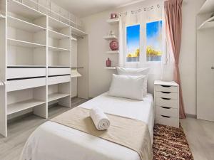 a white bedroom with a bed and a window at Maison de charme, Gorges Ardèche et Nature in Vagnas