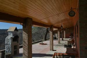 a patio with a wooden roof and a stone oven at Nukriani Keiptauni Residence in Sighnaghi