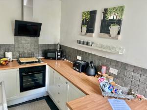 a kitchen with a wooden counter top in a kitchen at Mews Cottage in Torquay