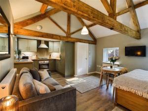 a living room with a couch and a kitchen at Wagtail Lodge in Foy
