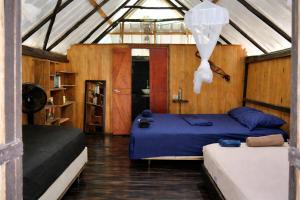 a bedroom with two beds in a room with wooden walls at Casa Alma in Capurganá