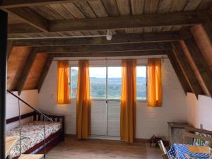 a bedroom with orange curtains and a large window at Don Cleto "La Mimosa" in Aiguá