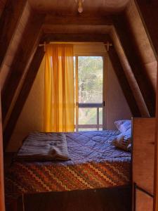 a bed in a room with a window at Don Cleto "La Mimosa" in Aiguá