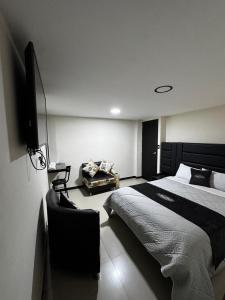 a bedroom with a bed and a flat screen tv at Hotel San Alejo in Ipiales
