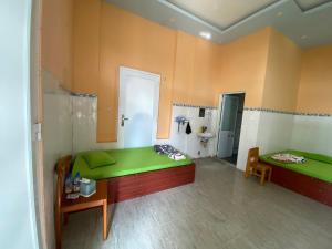 a room with two green beds and a bathroom at Kim An Sadec Garden House in Ấp Tân An (2)
