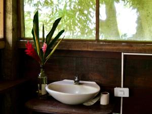 a bathroom with a sink and a vase with a flower at Casa Alma in Capurganá