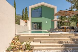 a house with a swimming pool and a patio at Black Mountain Villas in Kefallonia