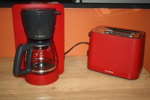 a red blender sitting next to a red toaster at Le cosy de Cholet près du PUY DUFOU in Cholet