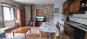 a kitchen with a table and a kitchen with a fireplace at El Pontarron Apartamentos in La Franca