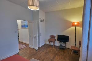 a living room with a television and a table and chairs at Ma maison du port in Guipry-Messac