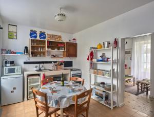 a kitchen with a table and chairs and a refrigerator at Ma maison du port in Guipry-Messac
