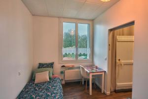 a room with a bed and a table and a window at Ma maison du port in Guipry-Messac