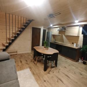 a living room with a table and a staircase at Lake House Jeziorsko in Ostrów Warcki