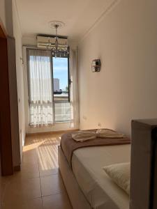 a bedroom with a bed and a large window at Valentino Apartments in Shkodër