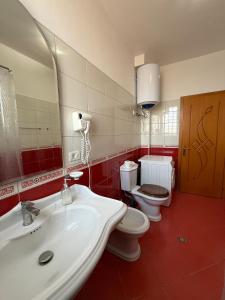 a bathroom with a sink and a toilet and a mirror at Valentino Apartments in Shkodër +15 photos