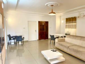 a living room with a couch and a table at Hebertogo Téléssou in Midja