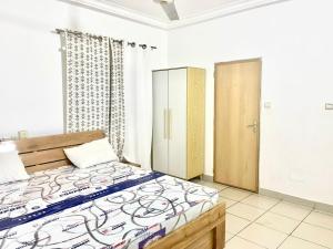 a bedroom with a bed and a cabinet in it at Hebertogo Téléssou in Midja