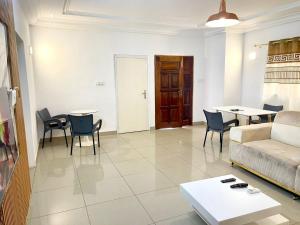 a living room with a couch and chairs and a table at Hebertogo Téléssou in Midja +1 photo