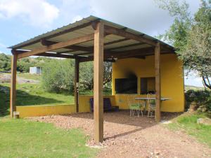 a yellow house with a table and chairs in it at Don Cleto "La Mimosa" in Aiguá