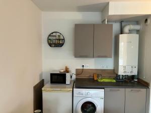 a kitchen with a washing machine and a microwave at Le 20 Joliot-Studio moderne in Mions