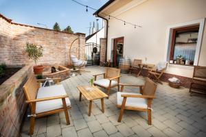 a patio with chairs and tables and a brick wall at Penzion Pawlowitz in Velké Pavlovice