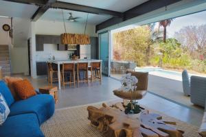 a living room with a blue couch and a kitchen at Ocean View Tranquility 2BR with Pool in San Juanillo