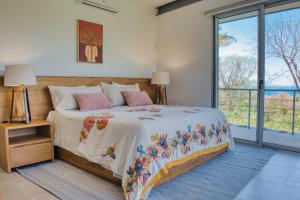 a bedroom with a bed and a large window at Ocean View Tranquility 2BR with Pool in San Juanillo
