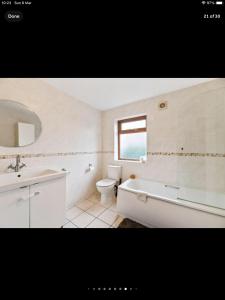a bathroom with a tub and a toilet and a sink at Beautiful views spacious 4 bed detached in Alvanley +25 photos