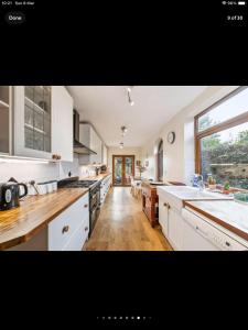 a large kitchen with white cabinets and a large window at Beautiful views spacious 4 bed detached in Alvanley