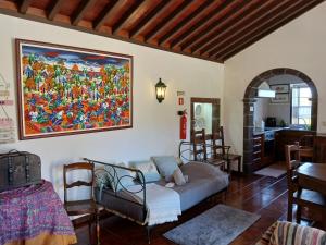 a living room with a couch and a painting on the wall at Casa da VíVí in Azenha de Baixo