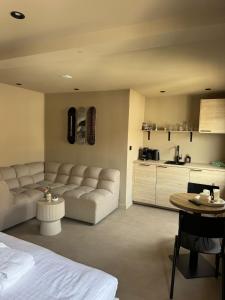 a living room with a couch and a table and a kitchen at Studio Strandkasteel, Free parking in Zandvoort