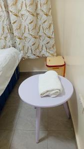 a white table with a towel on it next to a bed at Jayson Homes in Thika