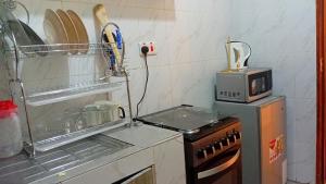 a kitchen with a stove and a microwave at Jayson Homes in Thika