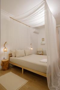 a white bedroom with a bed with a canopy at Casa Rosa Sé - Luxury Boutique Guest House in Faro