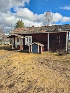 a wooden house with a yard in front of it at Vedmyrastugan in Delsbo
