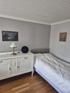 a bedroom with a bed and a dresser with a television at Vedmyrastugan in Delsbo