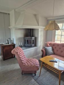 a living room with a pink couch and a coffee table at Vedmyrastugan in Delsbo