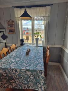 a dining room table with a blue and white table cloth at Vedmyrastugan in Delsbo +3 photos