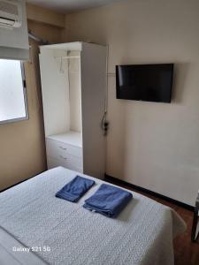 ein Schlafzimmer mit einem Bett, auf dem zwei blaue Handtücher liegen in der Unterkunft GORRITI VIEW in Partido Lomas de Zamora