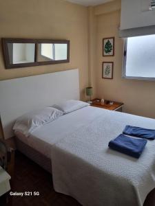 ein Schlafzimmer mit einem Bett, auf dem zwei blaue Handtücher liegen in der Unterkunft GORRITI VIEW in Partido Lomas de Zamora + 2 Fotos
