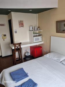 ein Schlafzimmer mit einem Bett, einer Mikrowelle und einem Tisch in der Unterkunft GORRITI VIEW in Partido Lomas de Zamora