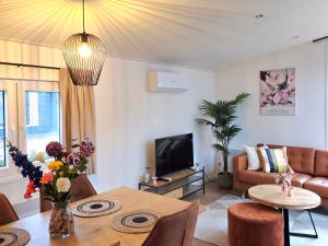 a living room with a table and a couch at Colibri Huisje in Haarle